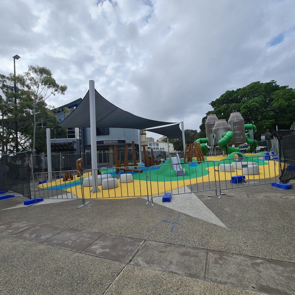Blue shade sails over a fenced playground