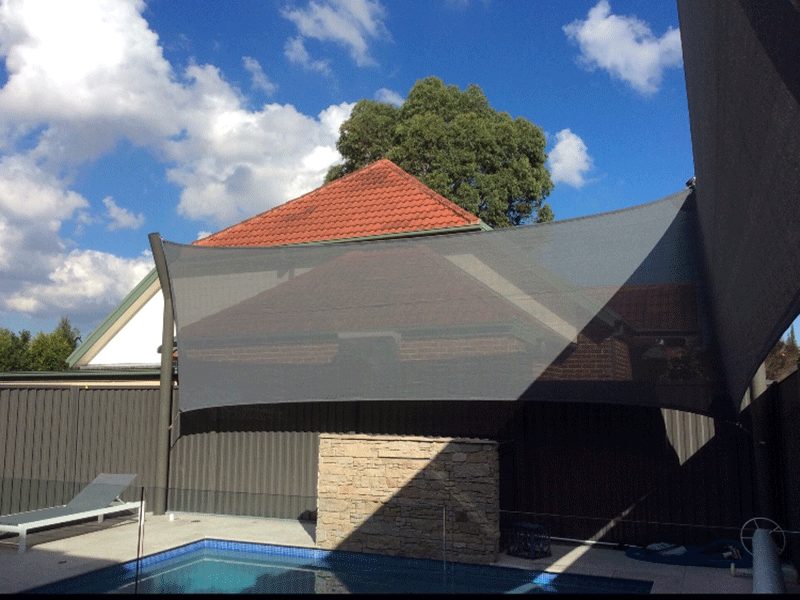 Privacy shade sail beside a home pool