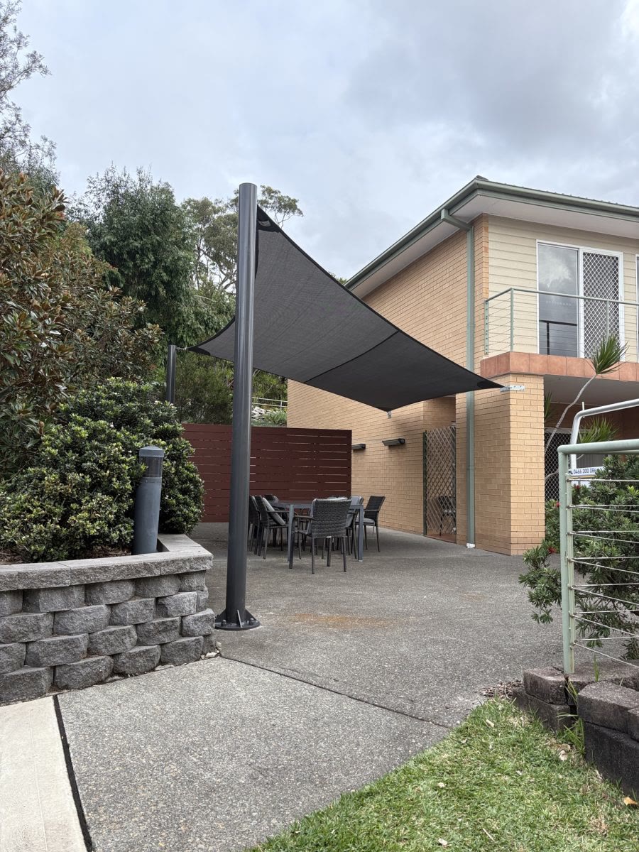 Residential hypar shade sail over a backyard patio